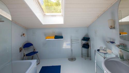 baño con bañera, lavabo y ventana en Ferienwohnung Neuhuber, en Bad Goisern