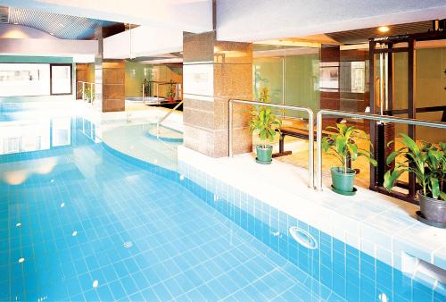 una gran piscina con plantas en un edificio en Metropark Hotel Macau, en Macau