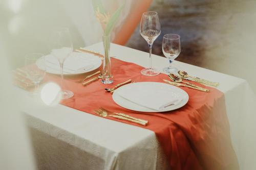 a table with two white plates and glasses of wine at Belmont Hotel Boracay near Newcoast Beach in Boracay