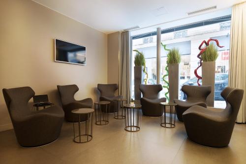 - une salle d'attente avec des chaises, des tables et une fenêtre dans l'établissement Arc de Triomphe Etoile, à Paris