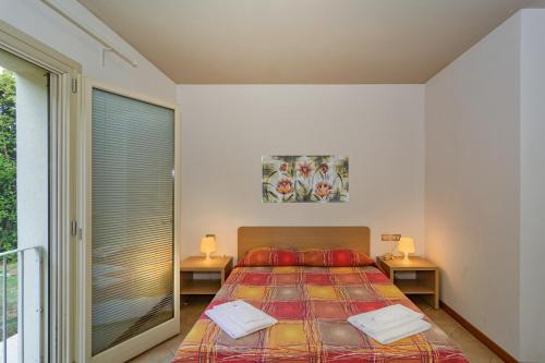 a bedroom with a bed with two tables and a window at Residence San Rossore in Pisa