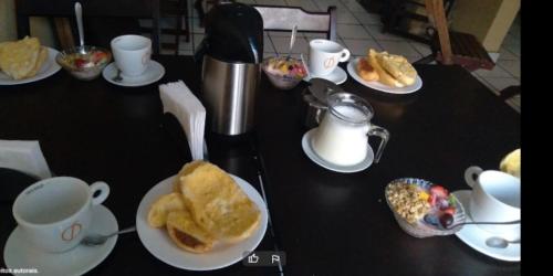 uma mesa preta coberta com pratos de comida e copos em Vila do Chaves bed breakfast em São Paulo