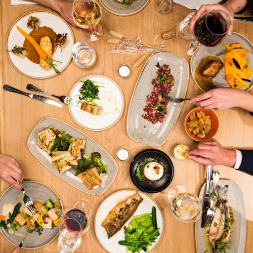 a wooden table with plates of food on it at Domaine du Gouverneur, Hôtel, Restaurant & Golf in Monthieux