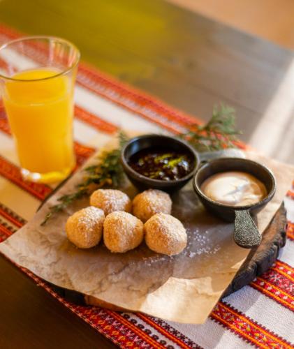a tray of food with donuts and dipping sauce at Bogolvar Retreat Resort in Antonovka
