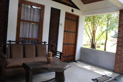 a cat sitting on a bench in front of a house at Green Cottage in Anuradhapura