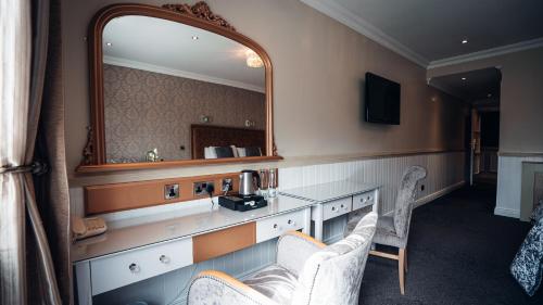 a hotel room with a vanity with a mirror at Beechlawn Hotel in Belfast