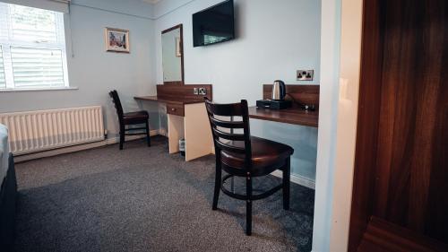 a room with a desk with a chair and a mirror at Beechlawn Hotel in Belfast