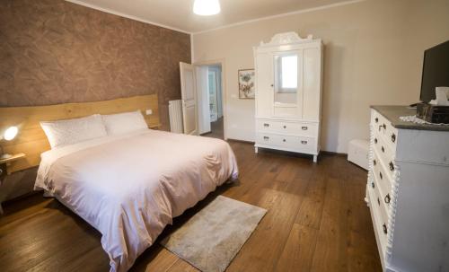 Un dormitorio con una cama, una cómoda y un espejo. en La Maison Apartment, en Fanano
