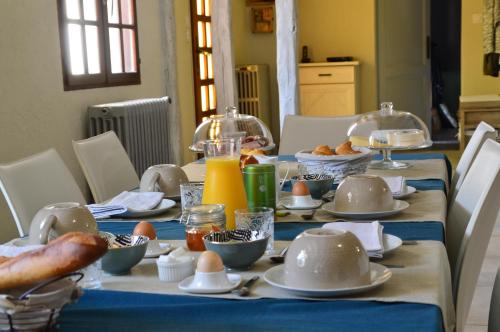 a table with a blue table cloth with eggs and orange juice at LA MAISON DE TRIBOULET Chambres et table d'hôtes -Amboise- in Pocé-sur-Cisse