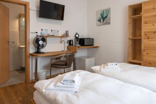 ネッカーズルムにあるGästehaus Neckarsulmのベッド2台と机があるホテルの部屋