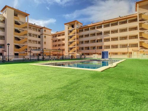 un gran edificio de apartamentos con una piscina en el patio en Ribera Beach 3 - 6606, en Mar de Cristal