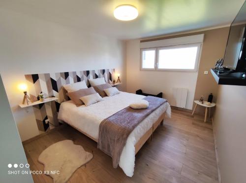 a bedroom with a large bed and a window at La pause au cub, maison cubique tout confort in Hinges