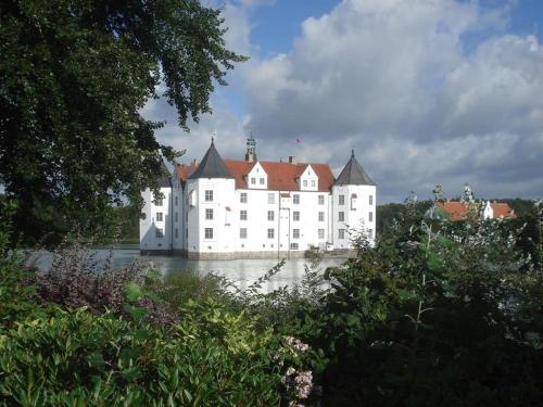 a large white building in the middle of the water at Ferienwohnung Pape in Glücksburg