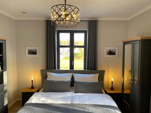a bedroom with a bed with a window and a chandelier at Bahnhof 1911 in Wolpertswende