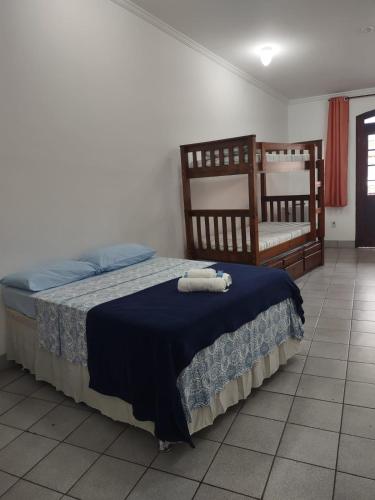 a bedroom with a bed with a blue blanket at Pousada Caravelas - Centro de Paraty in Paraty