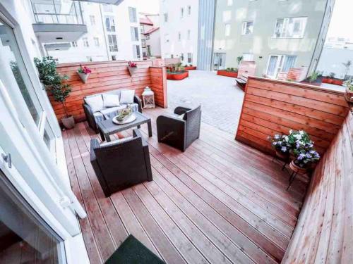 a wooden deck with chairs and a table on a balcony at Luxury New Apt in Downtown (83 sqm) in Reykjavík