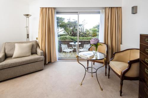 a living room with a couch and a table and chairs at The Atlantic Hotel - Small Luxury Hotels of the World in St Brelade