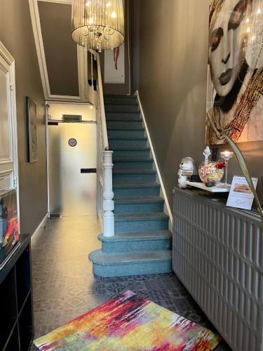 a hallway with a staircase with a white refrigerator at Le Vénitien in Liège