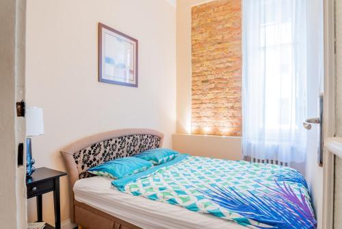 um quarto com uma cama com almofadas azuis e uma janela em SLEEP'N Budapest - free airport transfer em Budapeste
