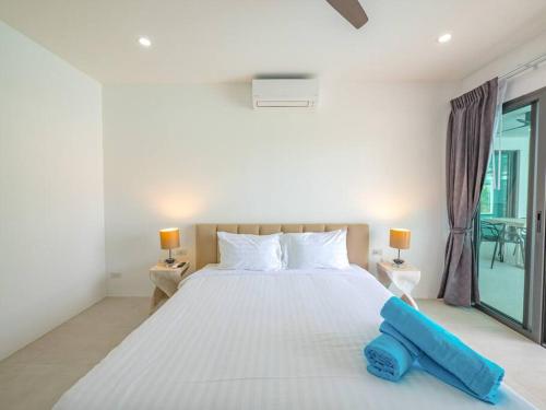 a bedroom with a large white bed and a window at Villa Selena in Lamai