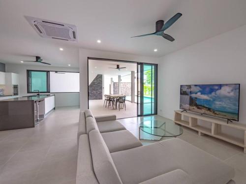a large living room with a couch and a kitchen at Villa Selena in Lamai