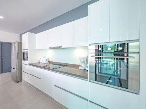 a kitchen with white cabinets and a stainless steel refrigerator at Villa Selena in Lamai