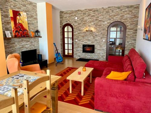 a living room with a red couch and a table at Apartment Albufeira Algarve in Albufeira