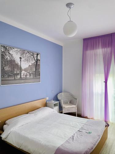 sypialnia z łóżkiem i fioletową ścianą w obiekcie Via Padova 165 w Mediolanie