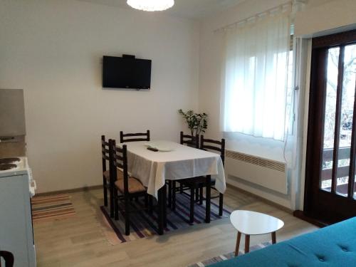 a dining room with a table and chairs and a tv at Apartman Otvoreno polje in Arandelovac