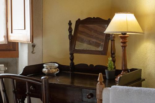 a lamp sitting on top of a dresser with a mirror at Agriturismo I Bonsi in Reggello