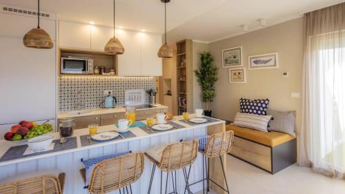 a kitchen with a counter with chairs and a table at One bedroom appartement at Mali Losinj 500 m away from the beach with sea view furnished terrace and wifi in Mali Lošinj