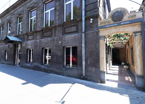 a building with an archway on a city street at Hotel Tigran Mets Yerevan in Yerevan