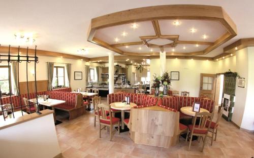 a restaurant with red chairs and tables in a room at Cafe Wastelbauerhof - Urlaub auf dem Bauernhof in Bernau am Chiemsee