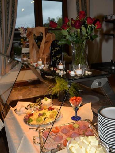 a table topped with plates of food and flowers at Cafe Wastelbauerhof - Urlaub auf dem Bauernhof in Bernau am Chiemsee