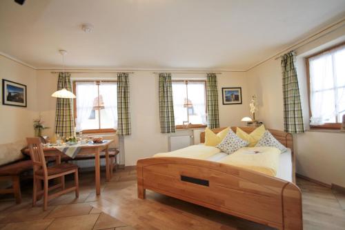 a bedroom with a bed and a dining room at Cafe Wastelbauerhof - Urlaub auf dem Bauernhof in Bernau am Chiemsee