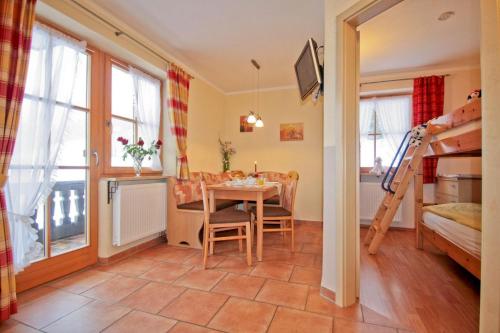 a room with a table and a room with a bunk bed at Cafe Wastelbauerhof - Urlaub auf dem Bauernhof in Bernau am Chiemsee
