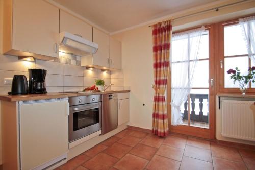 a kitchen with a sink and a stove top oven at Cafe Wastelbauerhof - Urlaub auf dem Bauernhof in Bernau am Chiemsee