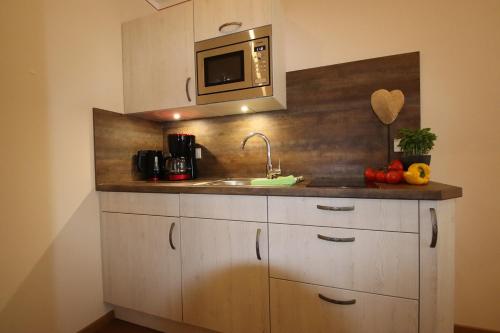 a kitchen with a sink and a microwave at Cafe Wastelbauerhof - Urlaub auf dem Bauernhof in Bernau am Chiemsee