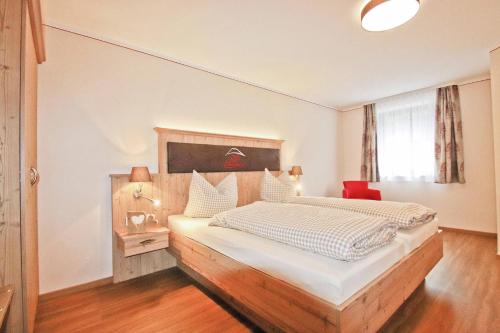 a bedroom with a large bed with a wooden headboard at Cafe Wastelbauerhof - Urlaub auf dem Bauernhof in Bernau am Chiemsee