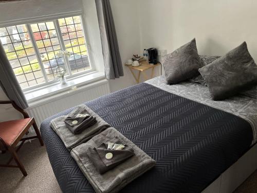 a bedroom with a bed with two towels on it at Siam cottage guesthouse over 300 years old with Thai restaurant in Moreton in Marsh
