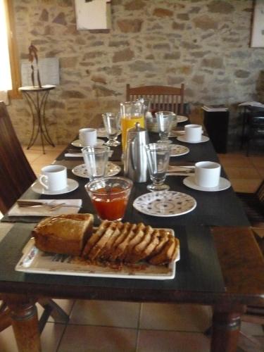 une table avec une assiette de nourriture dessus dans l'établissement La Maison Du Ruisseau, à Conilhac-Corbières