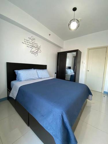 a bedroom with a large bed with blue sheets at A Cozy 2 Bedroom Unit with a Parking at Tower 2 South Residences SM Southmall in Manila