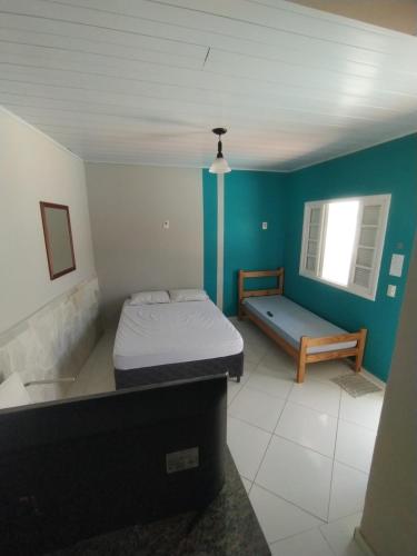 1 dormitorio con cama y banco. en Bertioga litoral, en Bertioga