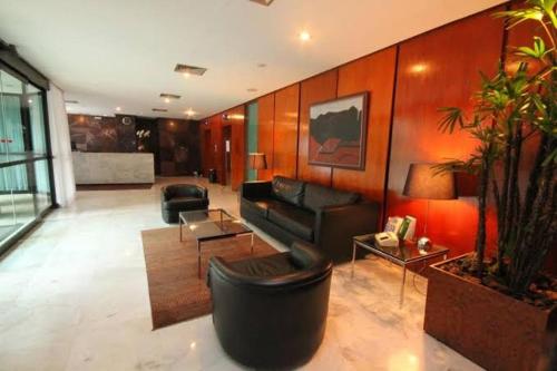 uma sala de estar com um sofá e uma mesa em Apart hotel Champagnat em Belo Horizonte
