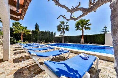 eine Reihe blauer Liegestühle neben einem Pool in der Unterkunft Villas Guzman - Flores in Benissa