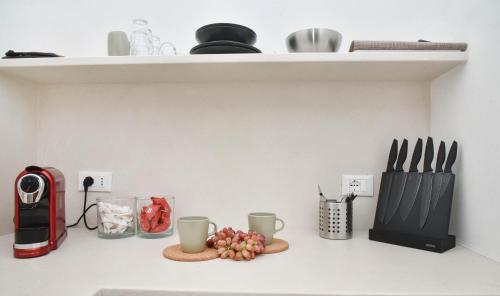 a kitchen counter with cups and utensils on a shelf at CASA FLAMI' 3 in Ostuni