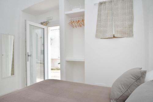 a white bedroom with a bed and a window at CASA FLAMI' 3 in Ostuni