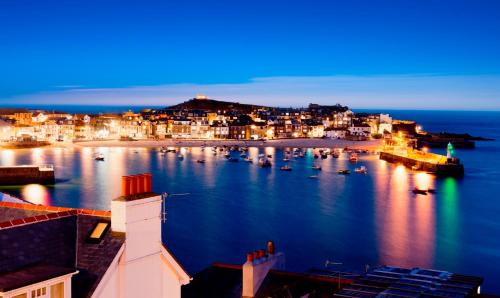 a view of a harbor at night with boats in the water at Pebble Cottage in Uny Lelant
