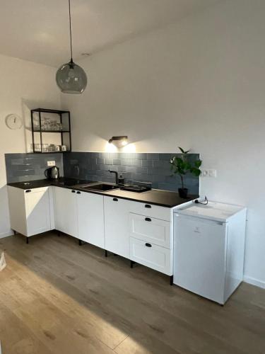 a kitchen with white cabinets and a sink at Apartamenty Komorniki in Komorniki