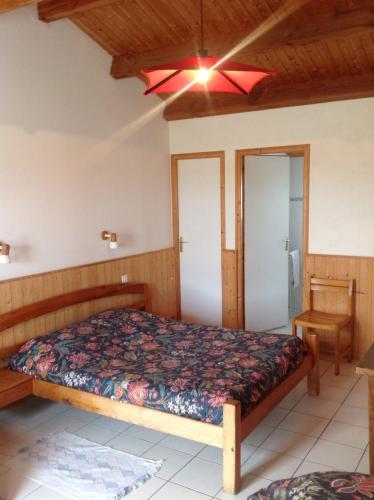 une chambre avec un lit et un ventilateur de plafond dans l'établissement Ferme Auberge L'Ile Sauvage, à Bouin